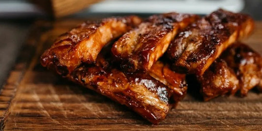 well grilled beef ribs on a wood plate to show how to grill perfect beef ribs with instant read thermometer