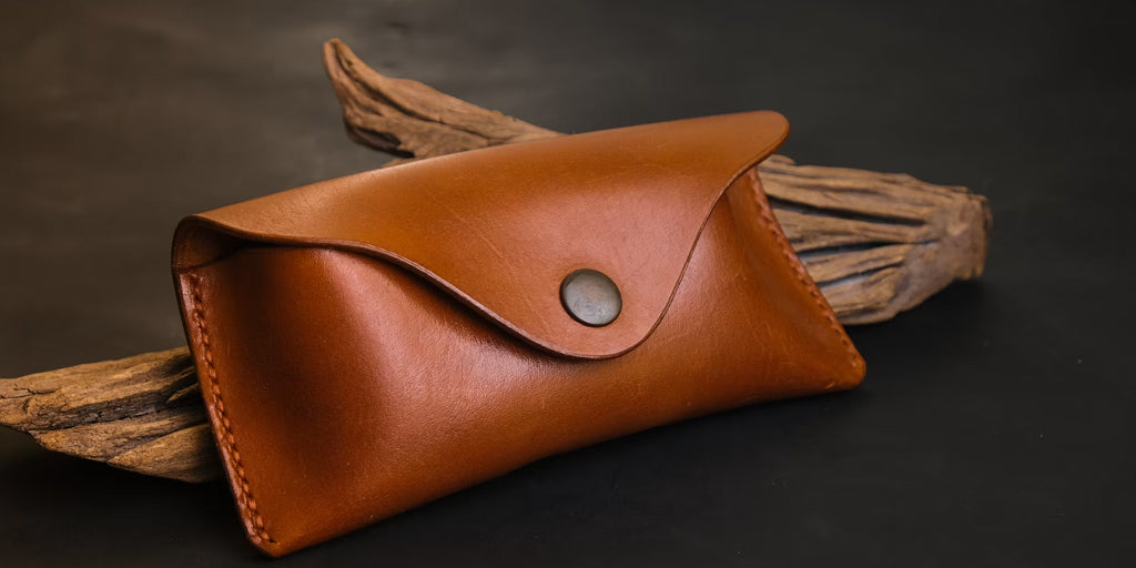 a brown leather eyeglasses case on a desk