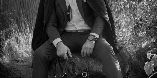 a fashion man wearing a watch and taking a clutch