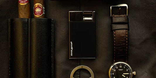 a leather cigar case, a lighter and a watch on a desk