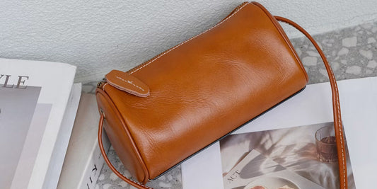a leather crossbody bag laying on a desk