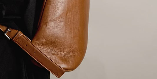 a woman takes a leather crossbody bag