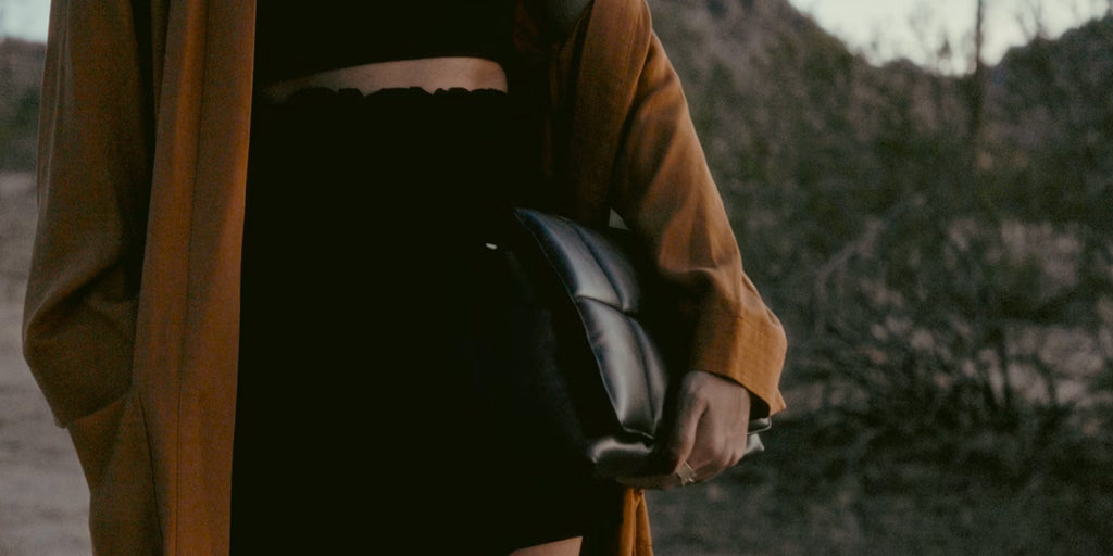 a women holding a leather pouch