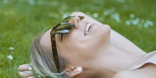 a lady with sunglasses on the green grassland