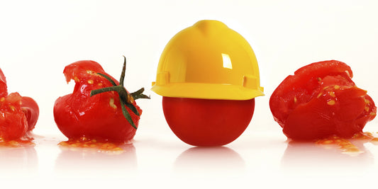 A tomato with helmet to emphasize food safety 