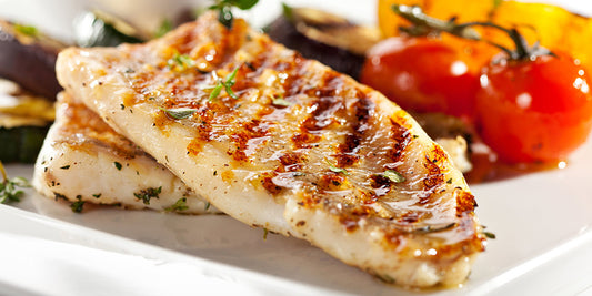 two cuts of well grilled walleye on a dish to show how to grill walleye professionally