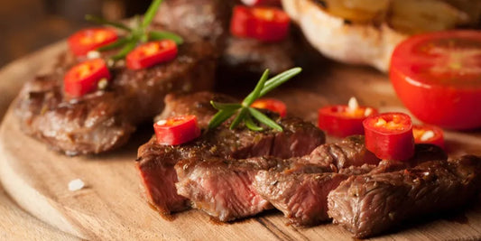 sliced grilled steaks on a wood plate to show how long to grill thin steak