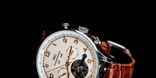 round silver-colored chronograph IWC watch with brown leather strap