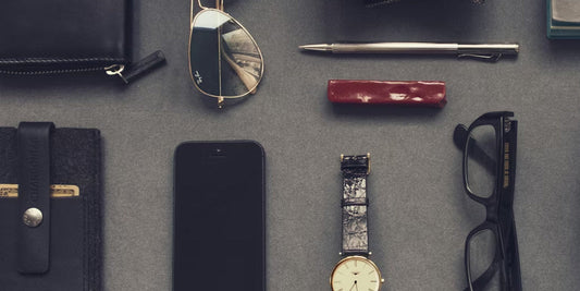 sunglasses, watches and travel accessories on a desk
