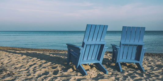 two blue chairs on the beach