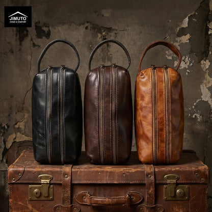 Three leather storage bags in black, brown, and rust on an old suitcase against a textured wall.