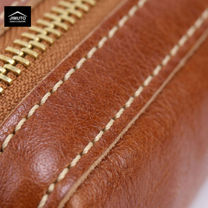 Close-up detail of a brown leather zipper pen pouch with gold-tone zipper and contrast stitching, showing the Jimuto brand logo in the top-left corner.
