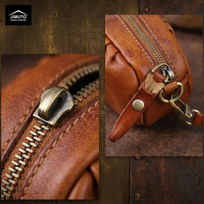 Close-up of a brown leather bag with a zipper and gold hardware on a textured background.