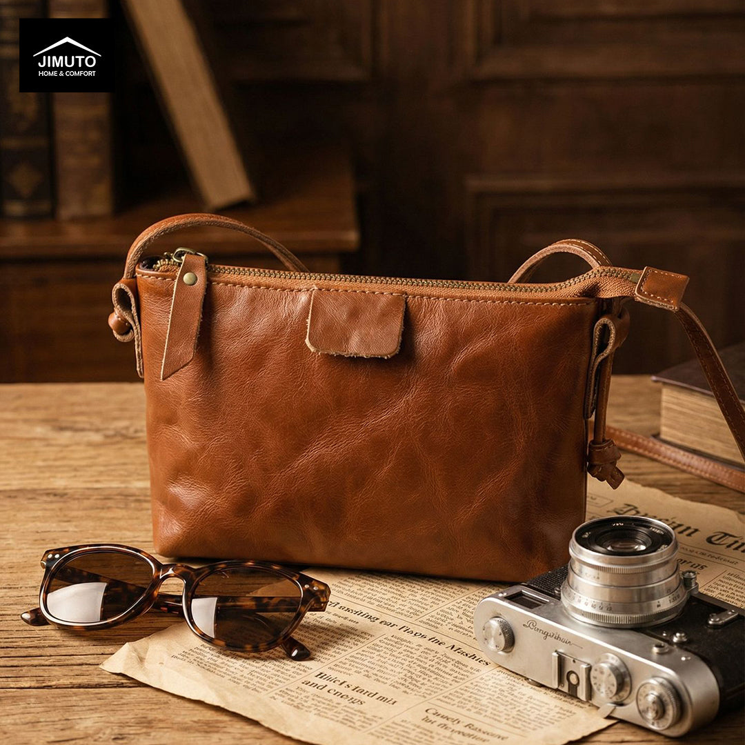 Brown leather crossbody bag on a a desk with 'JIMUTO' showing