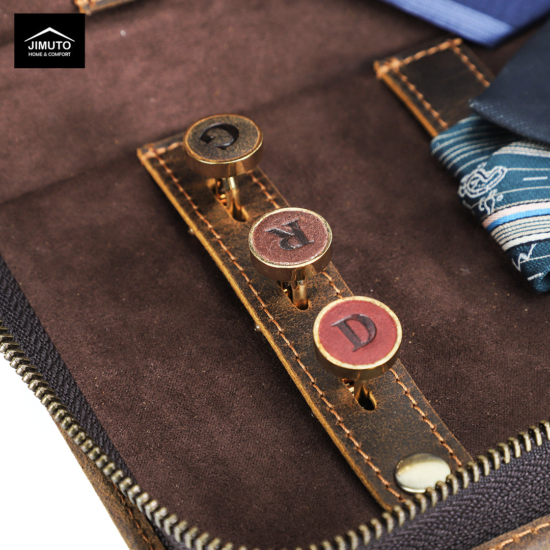 Close-up of a leather strap with metal buttons on a brown leather tie box, featuring the JIMUTO brand.