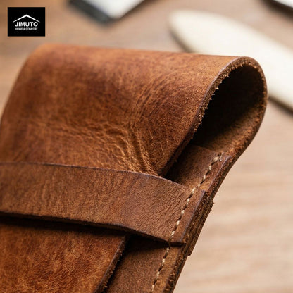 Close-up of a brown leather pen pouch with visible stitching, on a blurred background.
