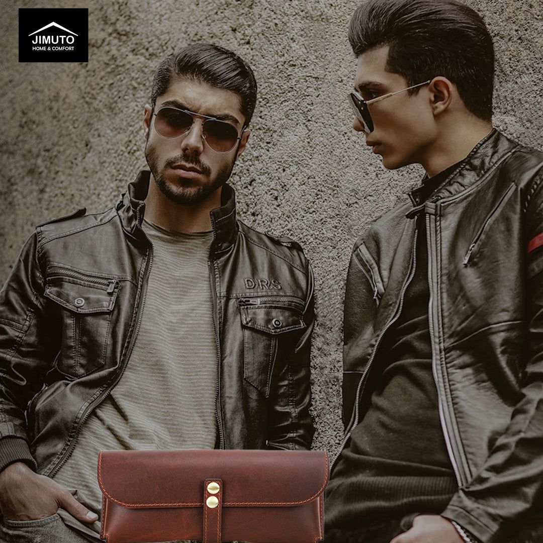 Two men in leather jackets with a brown leather sunglasses case in front of them, against a textured wall background.