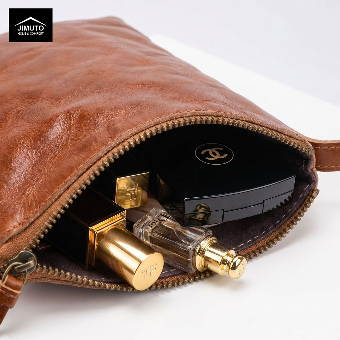 Brown leather clutch with gold and black perfume bottles on a white background
