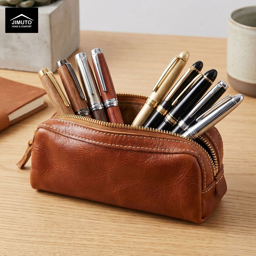 A brown leather zip pen pouch pencil case on a wooden desk, filled with assorted pens. A Jimuto logo block is visible in the top-left corner.
