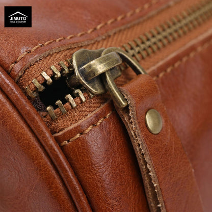 Close-up of a brown leather cosmetic and storage bag with brass zipper and stitching details, featuring the JIMUTO brand.