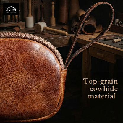 Brown leather coin wallet with 'Top-grain cowhide material' text on a workshop background.