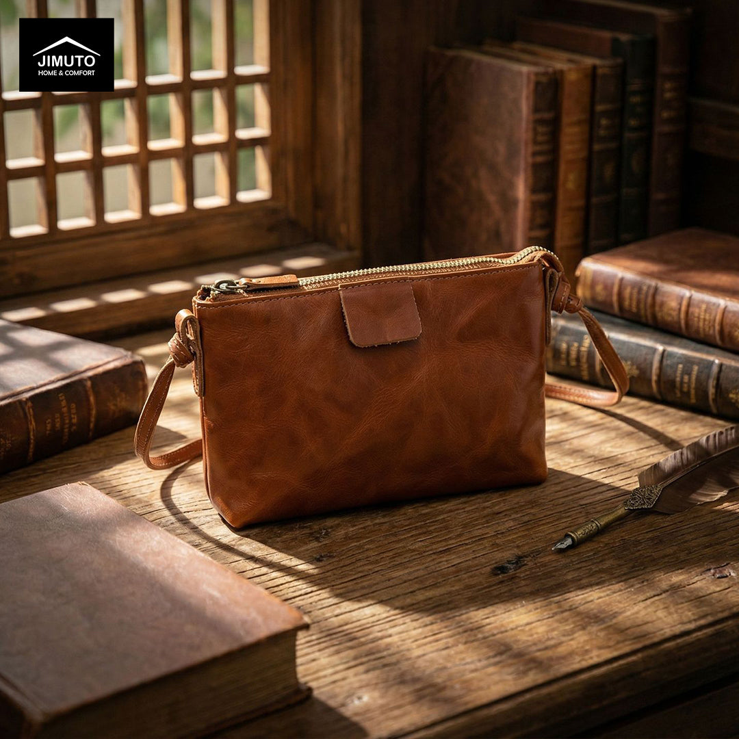a Brown leather crossbody bag on a wood desk 