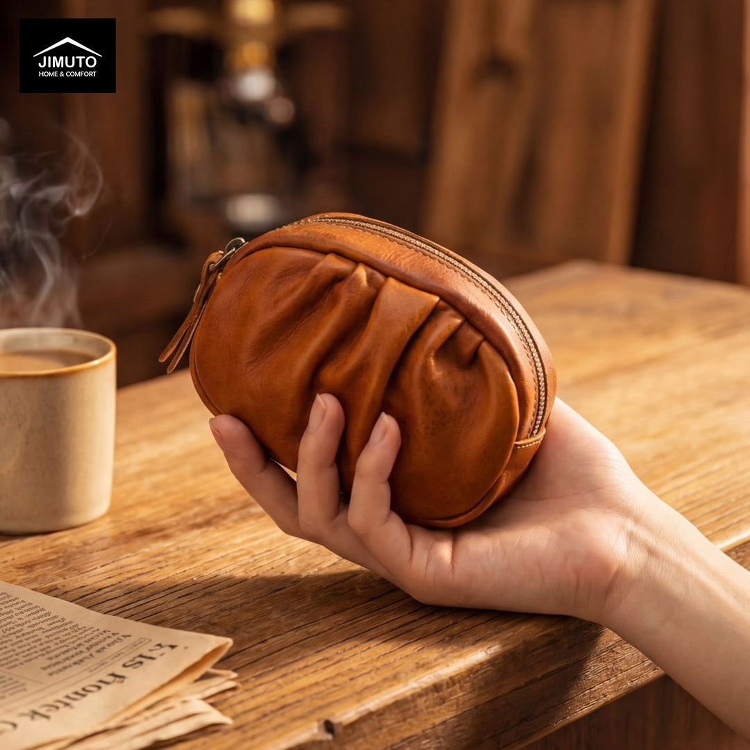 Hand holding a brown leather pouch on a wooden table with a cup of coffee and newspaper in the background.