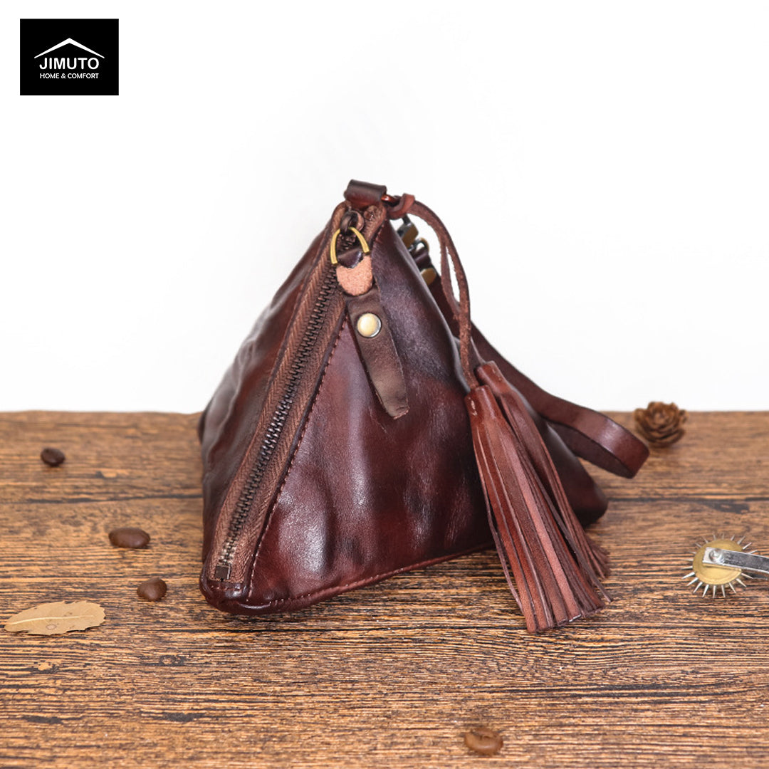 Coffee Brown leather handbag with tassel on a wooden surface, featuring the JIMUTO brand.