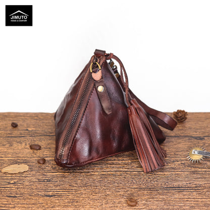 Coffee Brown leather handbag with tassel on a wooden surface, featuring the JIMUTO brand.