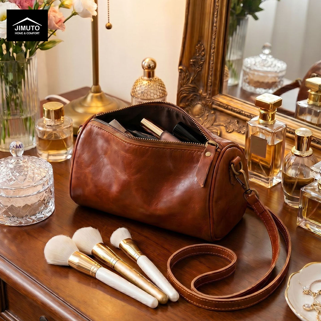 Brown cosmetic and storage leather bag with makeup brushes and perfume bottles on a wooden surface.