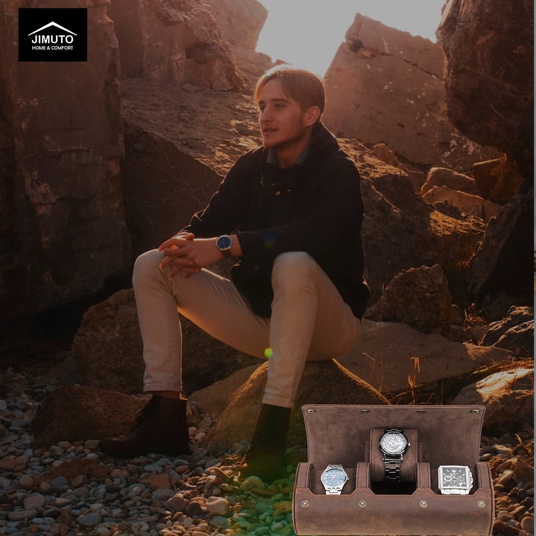 Man sitting on rocks with a watch in hand, next to an open watch case displaying three watches.