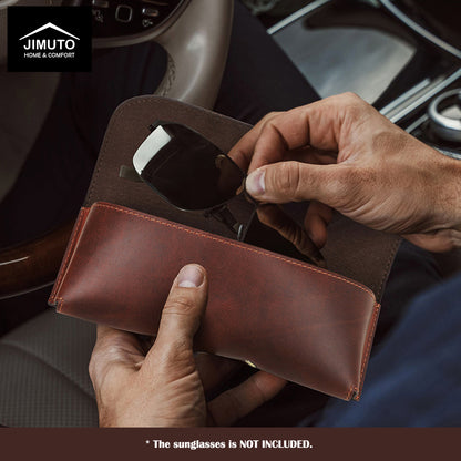 Person holding a brown leather sunglasses case with sunglasses inside, car interior background.
