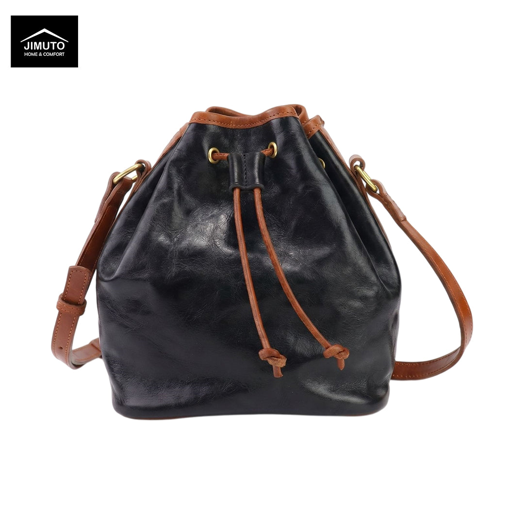 A black top-grain leather bucket bag with tan leather trim, drawstring closure, and a detachable shoulder strap, shown on a white background with a Jimuto logo in the top-left corner.