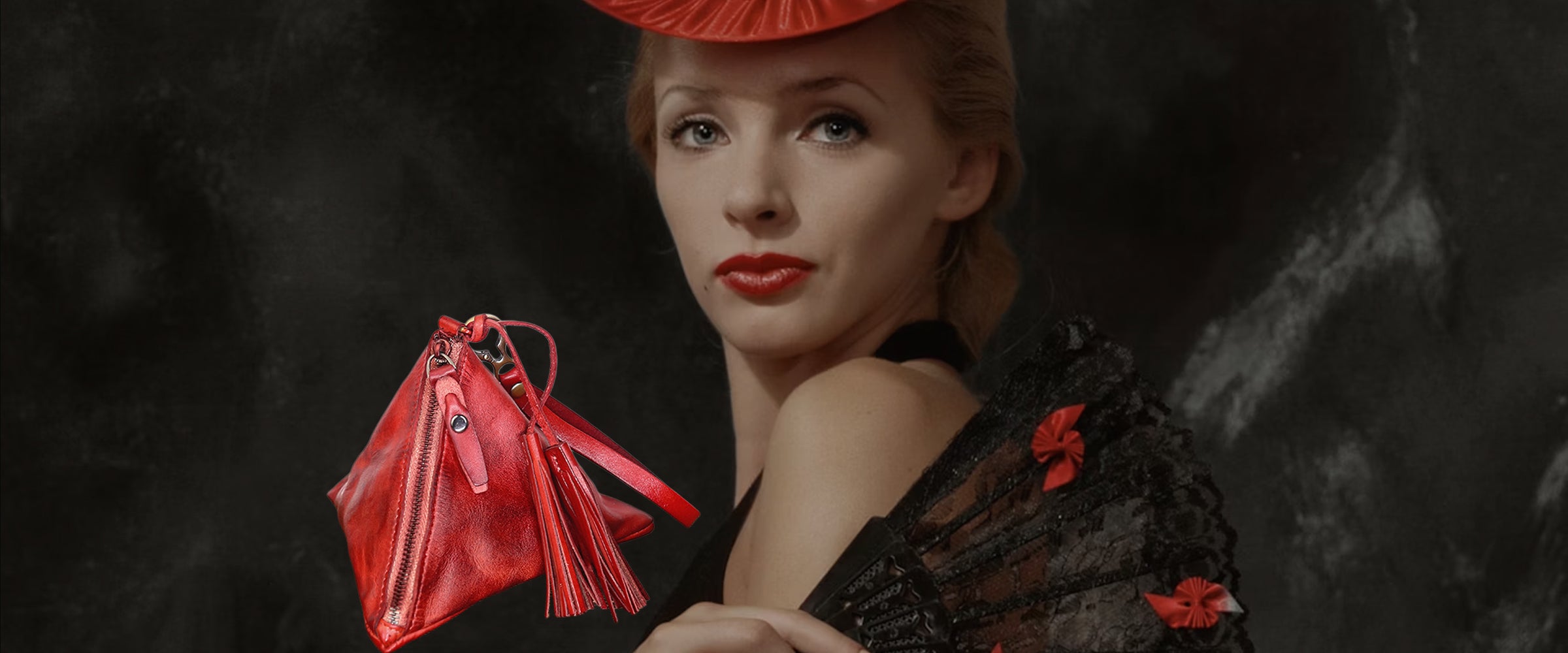 Woman holding a red handbag against a dark background