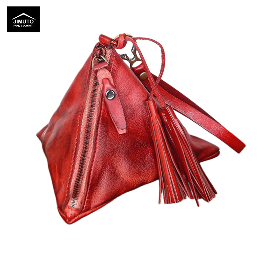 A red full-grain leather clutch with a triangular silhouette, featuring a front zipper, a hanging tassel charm, and a long strap, shown on a white background with a Jimuto brand logo in the top-left corner.
