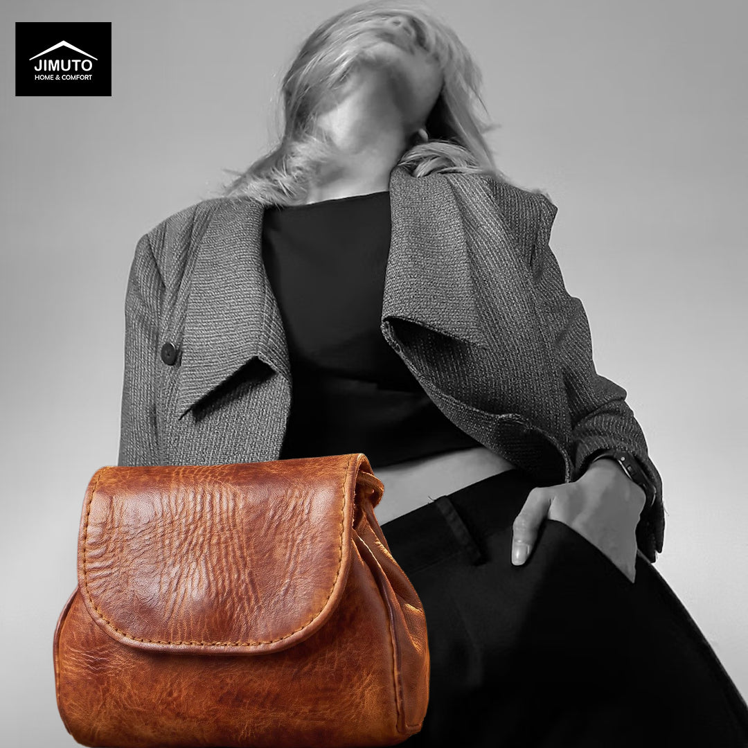 A model wearing a gray blazer and black top carries a brown leather pouch. The image is desaturated with a black-and-white effect on the model, while the bag retains its natural color.