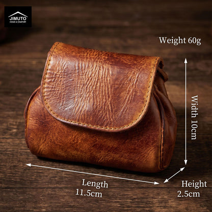 A brown leather pouch with a flap closure, shown on a dark wooden surface with dimension arrows and text indicating length 11.5cm, width 10cm, height 2.