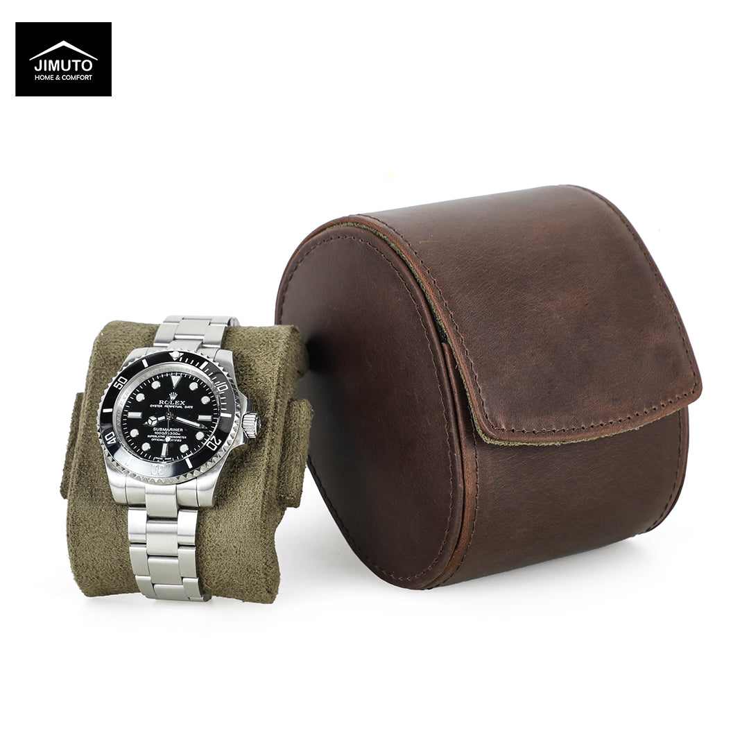 A silver stainless steel watch with a black dial and bezel is displayed on an olive green fabric watch stand next to a brown leather egg-shaped watch case on a white background. The Jimuto brand logo is visible in the top-left corner.