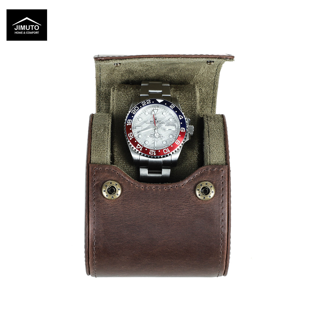 A wristwatch with a silver metal bracelet and a red, white, and blue bezel sits inside an open brown leather watch case with an olive green interior. The Jimuto brand logo is visible in the top-left corner.