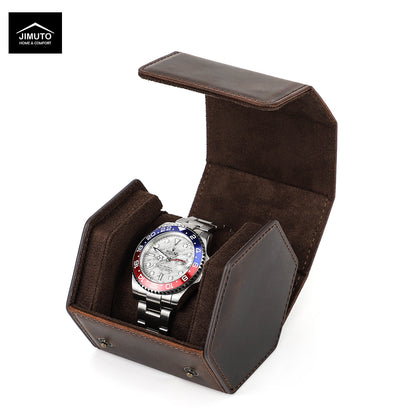 A wristwatch with a silver metal bracelet and a blue, red, and black bezel sits inside an open dark brown hexagonal leather watch box. The Jimuto brand logo is visible in the top-left corner on a white background.