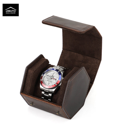A wristwatch with a silver metal bracelet and a blue, red, and black bezel sits inside an open dark brown hexagonal leather watch box. The Jimuto brand logo is visible in the top-left corner on a white background.