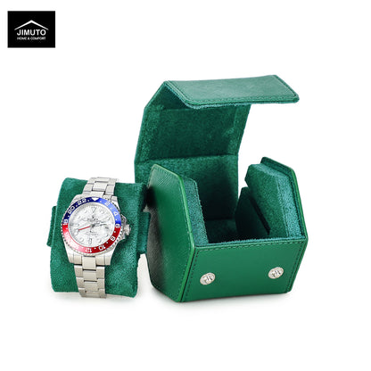 A silver stainless steel watch with a white dial and a red and blue bezel is displayed on a green watch cushion next to an open matching green saffiano leather watch box. The Jimuto brand logo is visible in the top-left corner.