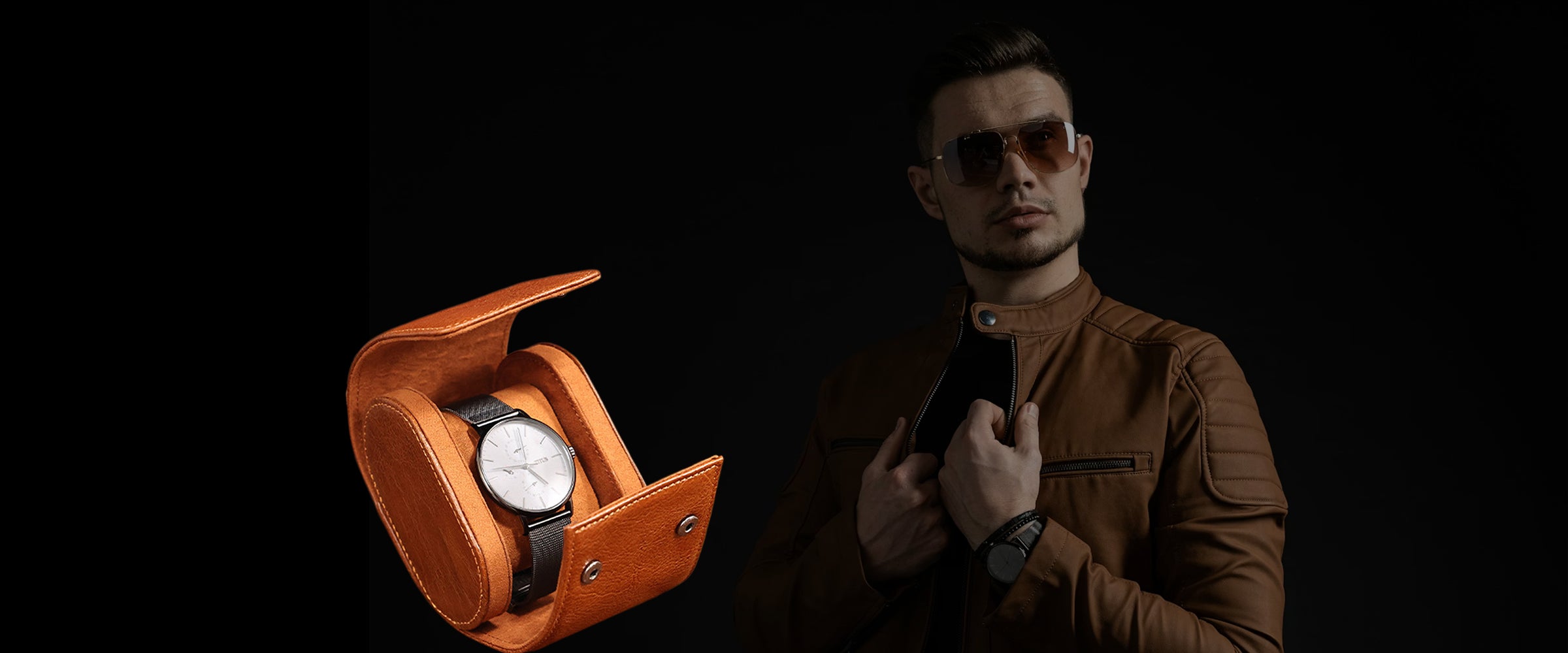 Man holding a watch with an open orange leather watch case on a black background