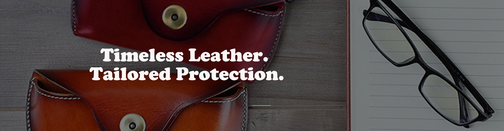 Leather eyeglasses cases with text 'Timeless Leather. Tailored Protection.' on a wooden surface.