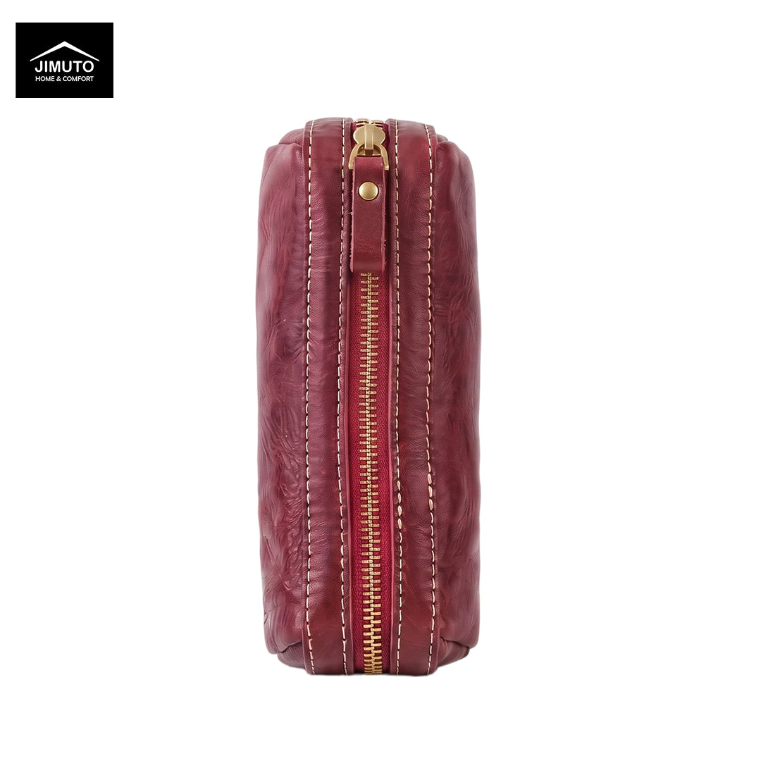 A vertical rectangular leather pen pouch in a deep burgundy red, featuring a central gold-tone zipper with white contrast stitching and a small gold rivet. The Jimuto brand logo is visible in the top-left corner on a plain white background.