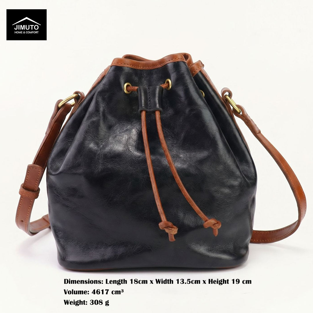 Black top-grain leather bucket bag with brown leather trim, drawstring closure, and adjustable shoulder strap, shown on a white background with product dimensions and weight text below.